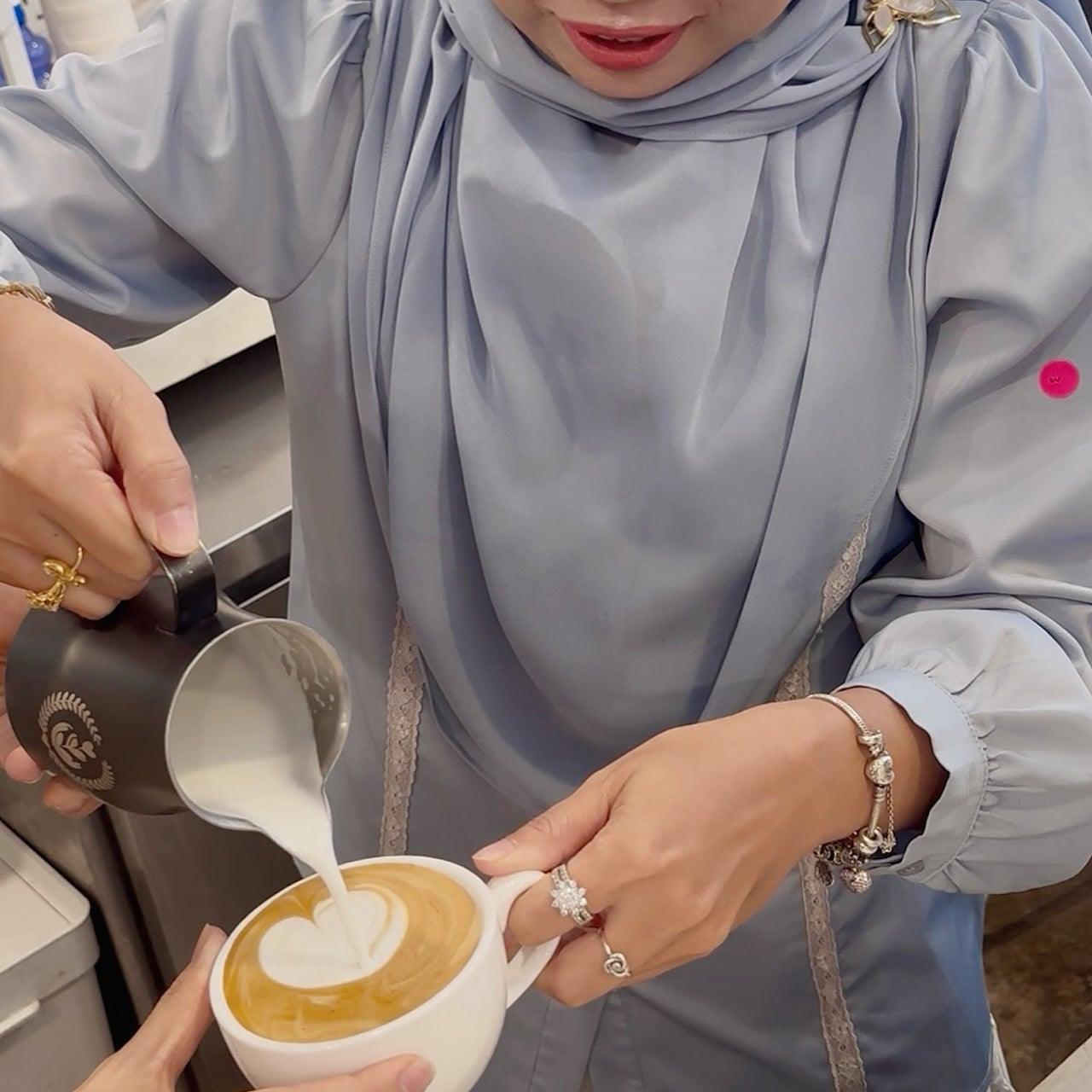 Person pouring milk into a cup of coffee